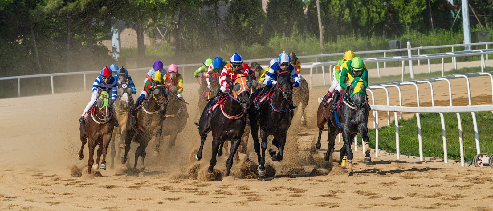 Jockeys and horses racing down a dirt track.